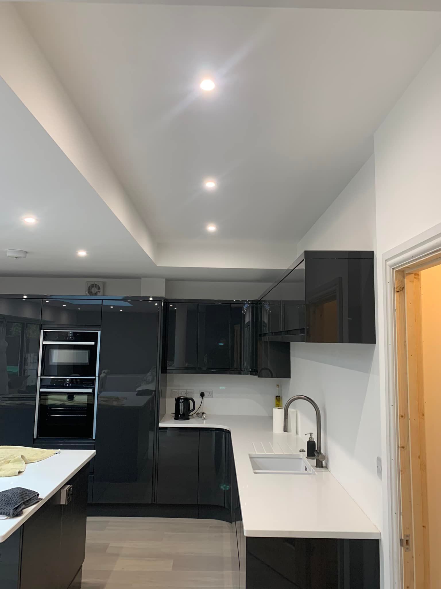 Black kitchen cupboard and a white ceiling with LEDs in it