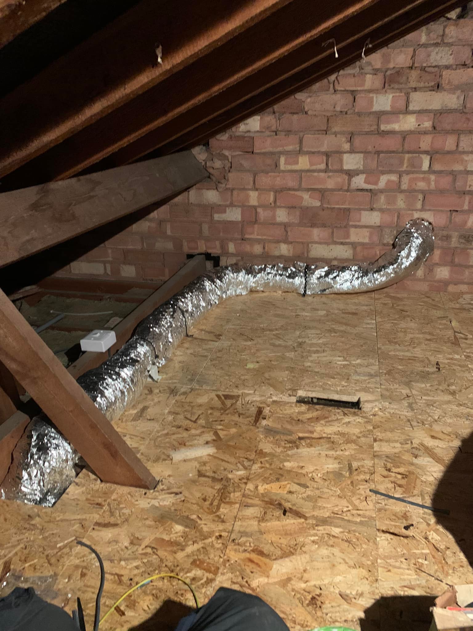 Extractor fan ducting leading outside through loft wall
