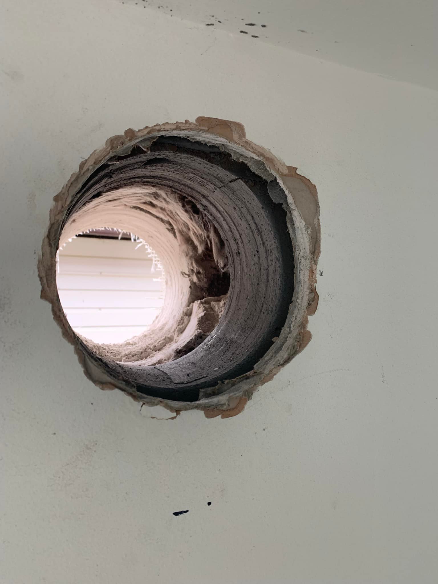 Large hole for extractor fan drilled in wall